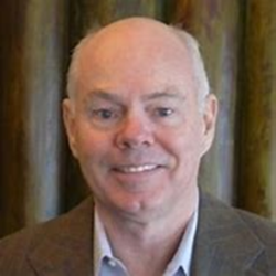 A headshot of Dr. David Braddock in a brown suit jacket.