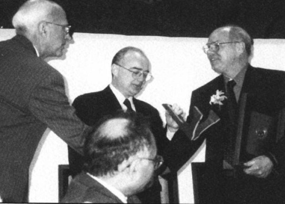 Dr. Braddock on a stage receiving the University Scholar Award from University of Illinois President.