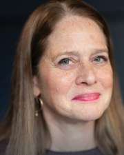 Katy Neas, a middle-aged woman with long light brown hair and freckles.