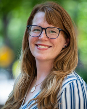 An image of Lydia Dawson, a woman with long brown hair and glasses smiling.